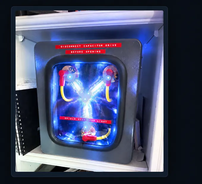 Vintage gray enclosed apparatus with glass components, red electrical connectors, and warning labels